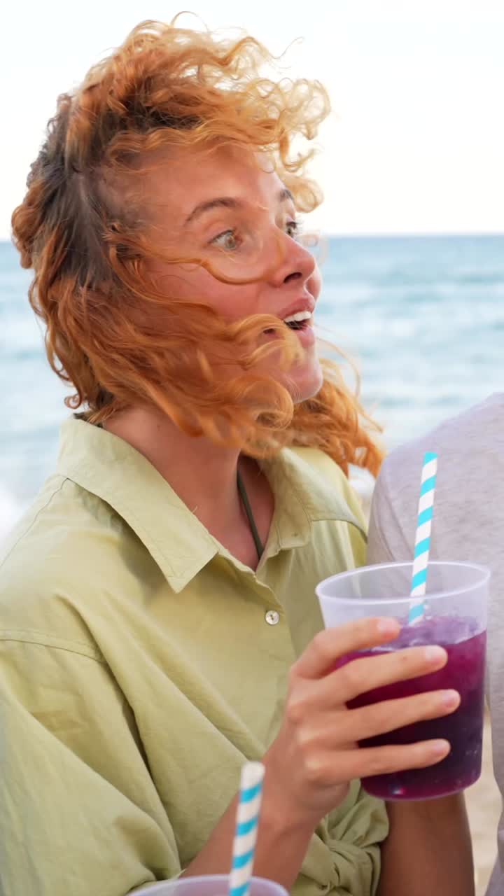 Friends toasting at the beach with drinks