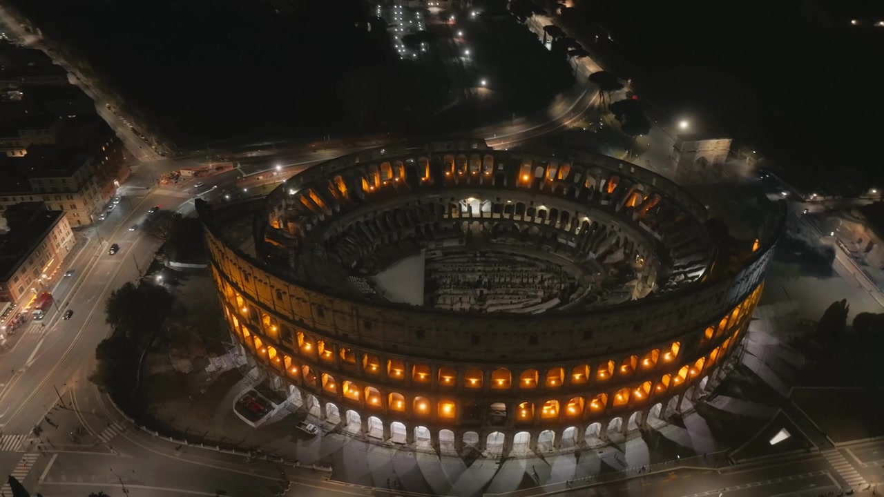 Colisée illuminé à Rome, vue aérienne de nuit par drone, Italie, avec les rues et bâtiments environnants de la ville. Plan en plongée