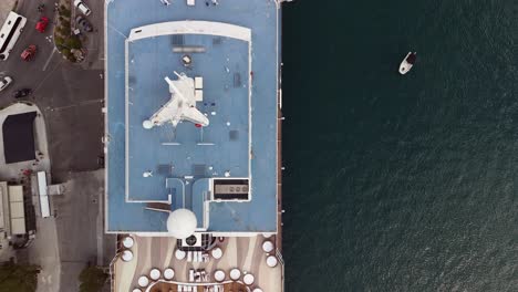 overhead flyover looks down on to large cruise ship moored at pier