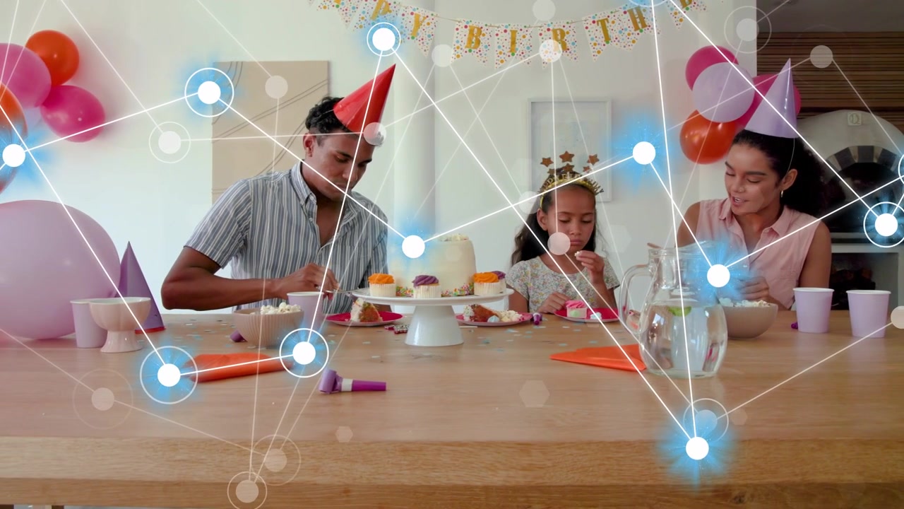 Familie beginnt am Partytisch zu essen, teilt Kuchen, während sich ein Technologieknoten-Overlay davor aufbaut.