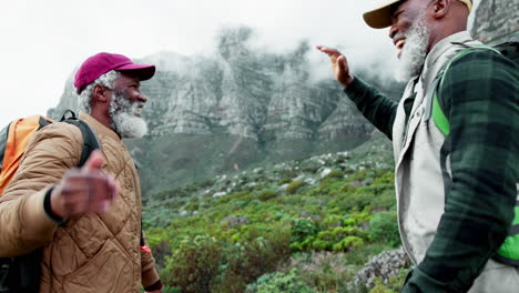 two senior men celebrate success on mountain hike