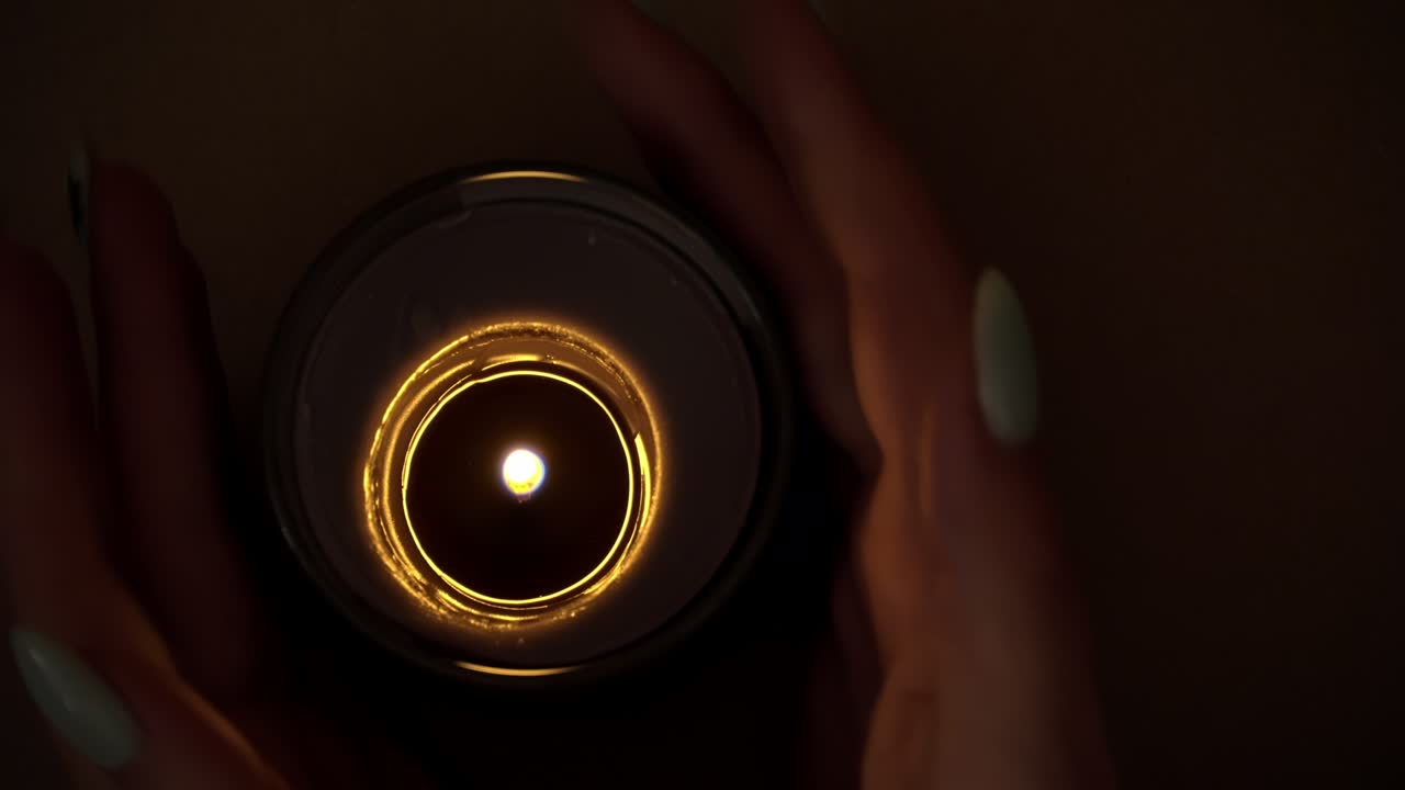 Candle Burns Atmospherically in the Hands of a Girl with a Beautiful Manicure
