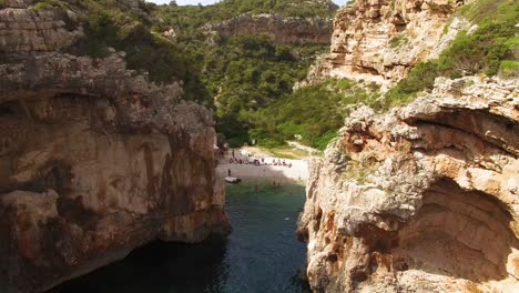 Eine-Luftaufnahme-Zeigt-Touristen,-Die-Den-Strand-Von-Stiniva-In-Vis-Kroatien-Genießen