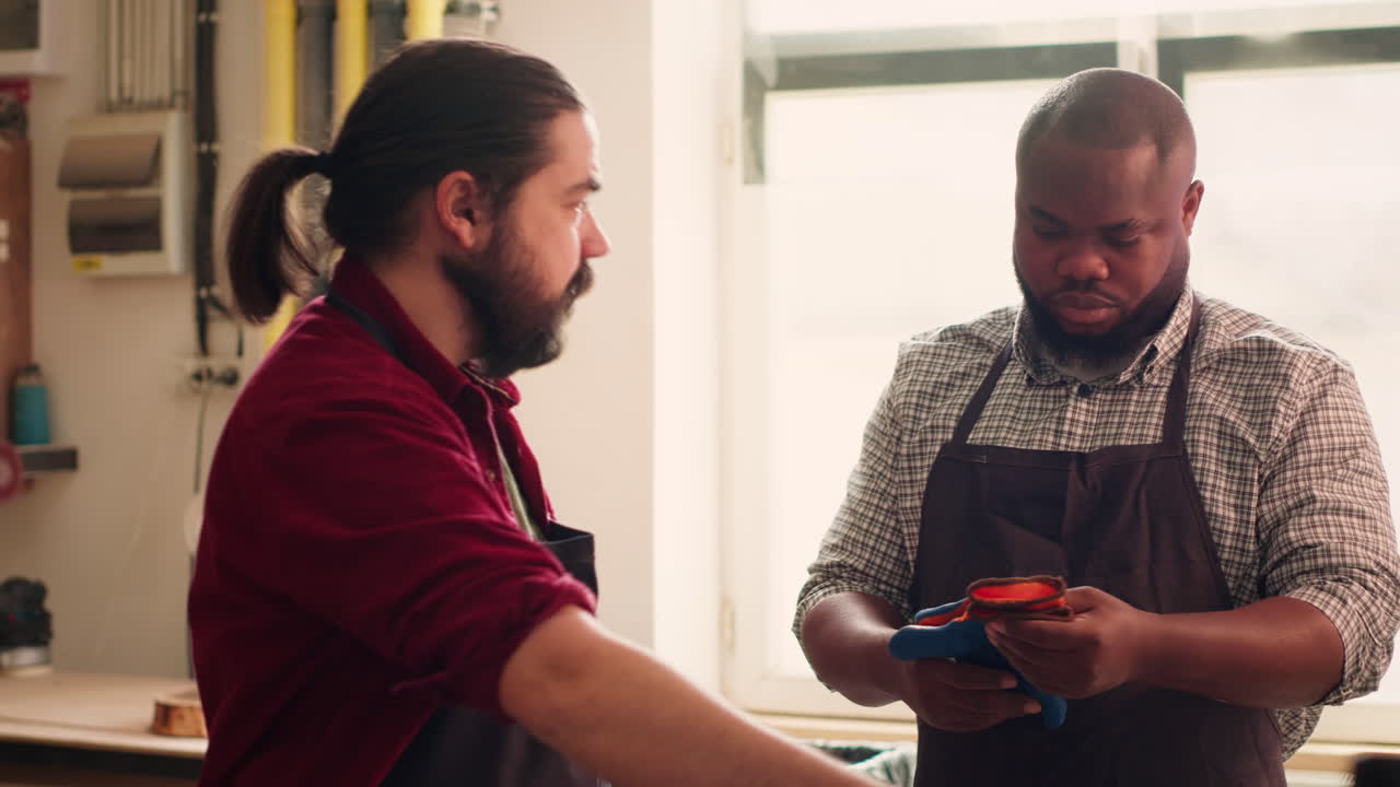 Master in woodworking shop giving worker protection gloves