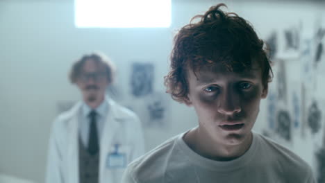 portrait of young patient staring at camera in psychiatric ward