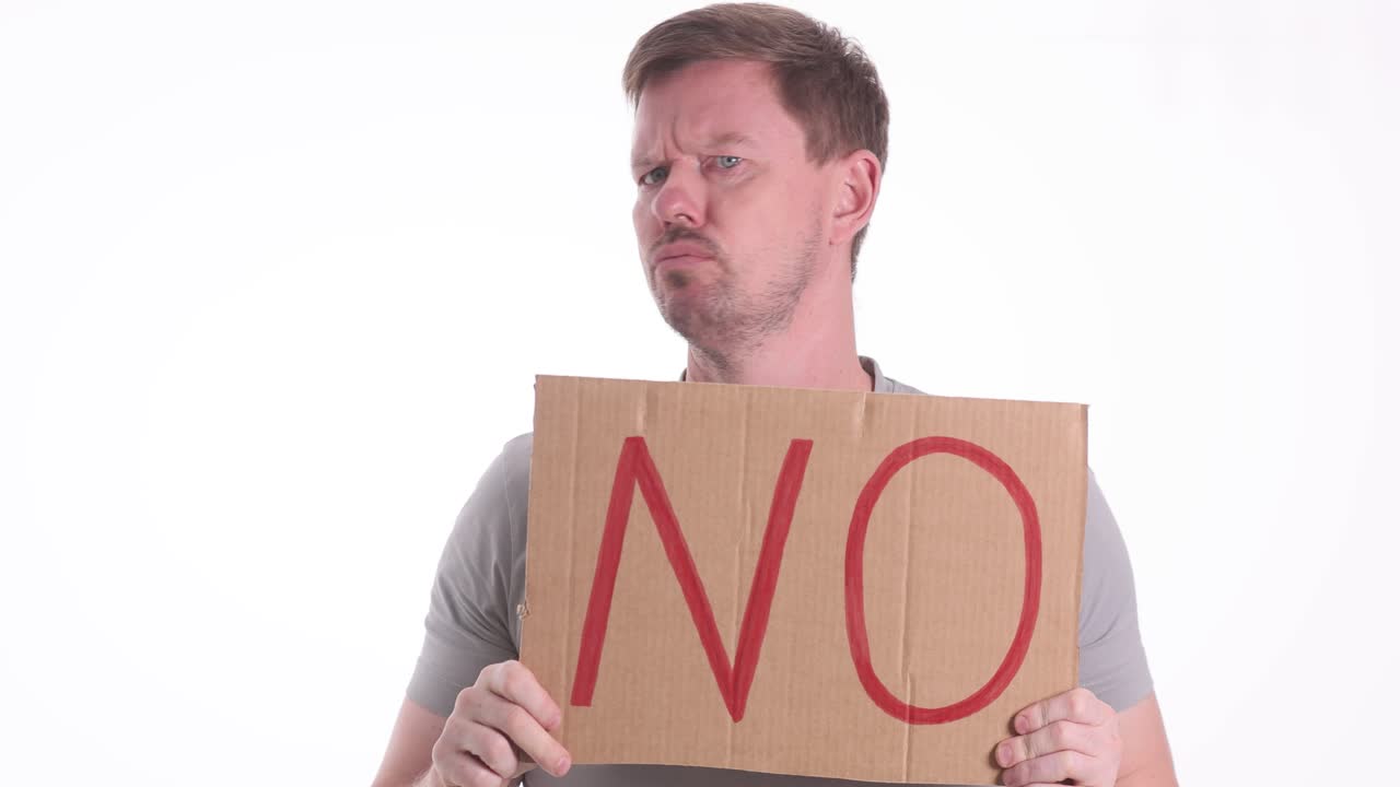 A man holding a 'NO' sign with a displeased expression