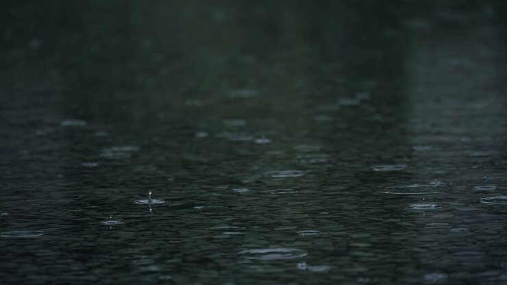 Slow motion of rain with splashes on wet asphalt surface