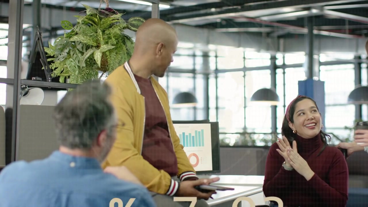 Coworkers at desk tapping tablet, revealing animated graphs over group for business analytics