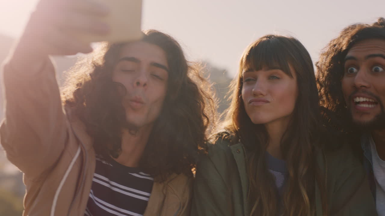 grupo feliz de amigos disfrutando de una fiesta de fin de semana en la azotea al atardecer tomando fotos de selfie usando teléfonos inteligentes compartiendo la reunión de fin de semana en las redes sociales