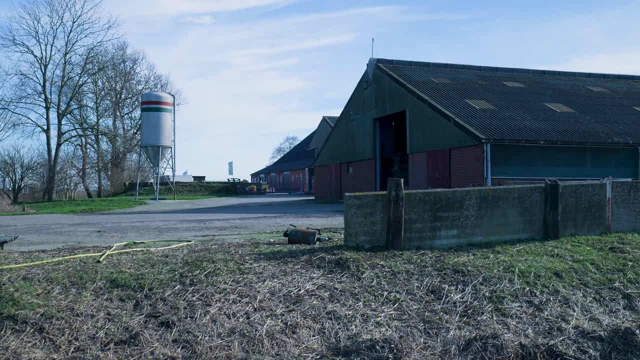 Quiet Farm Landscape with Barns and Silo Under Blue Sky