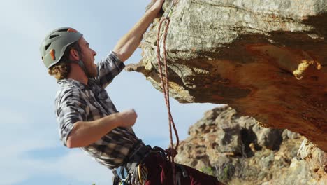 Mountaineer-trying-to-climb-up-on-the-hill-with-the-help-of-rope-4k
