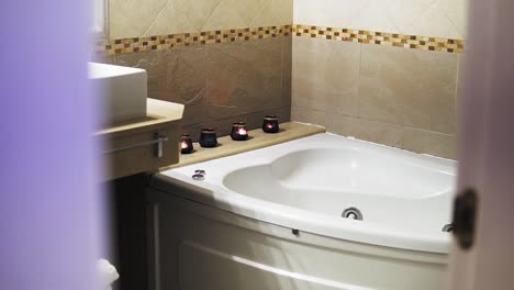 pequeño baño romántico con una bañera en forma de corazón y velas, interior del baño
