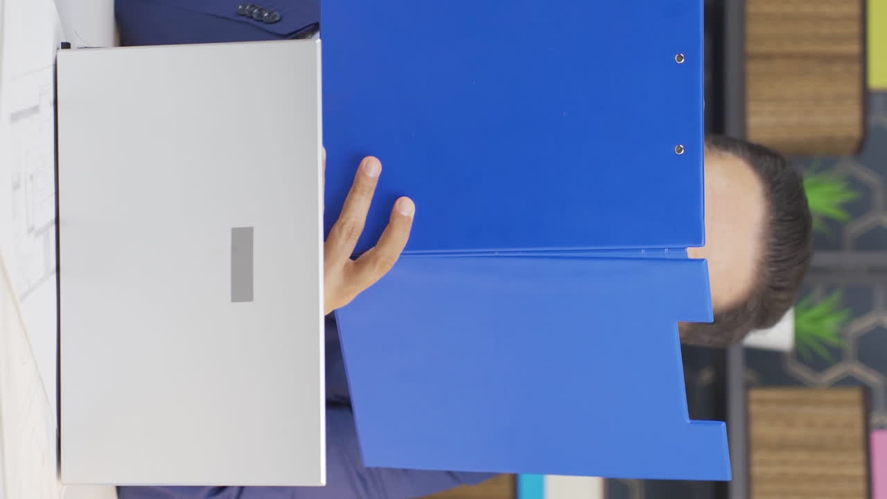 video vertical de un hombre de negocios alegre trabajando en archivos.