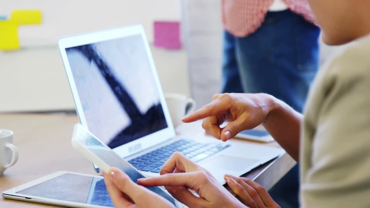 ejecutivos discutiendo por computadora portátil y teléfono móvil