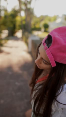 young woman wearing pink baseball cap and white shirt