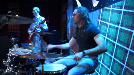 drummer playing on drum set on stage.