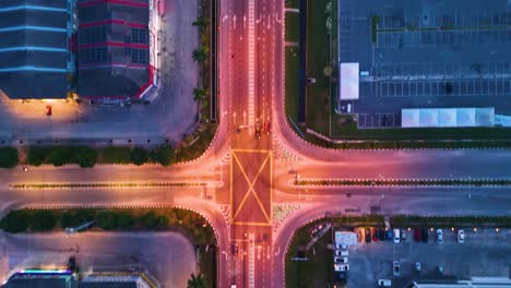aerial: traffic in a street of kota bharu at dawn with blue hour light in the state of kelantan, malaysia, top down drone shot
