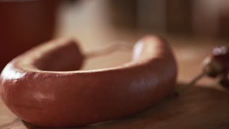 delicious turkish beef sucuk fall on a wooden plate in slow motion.