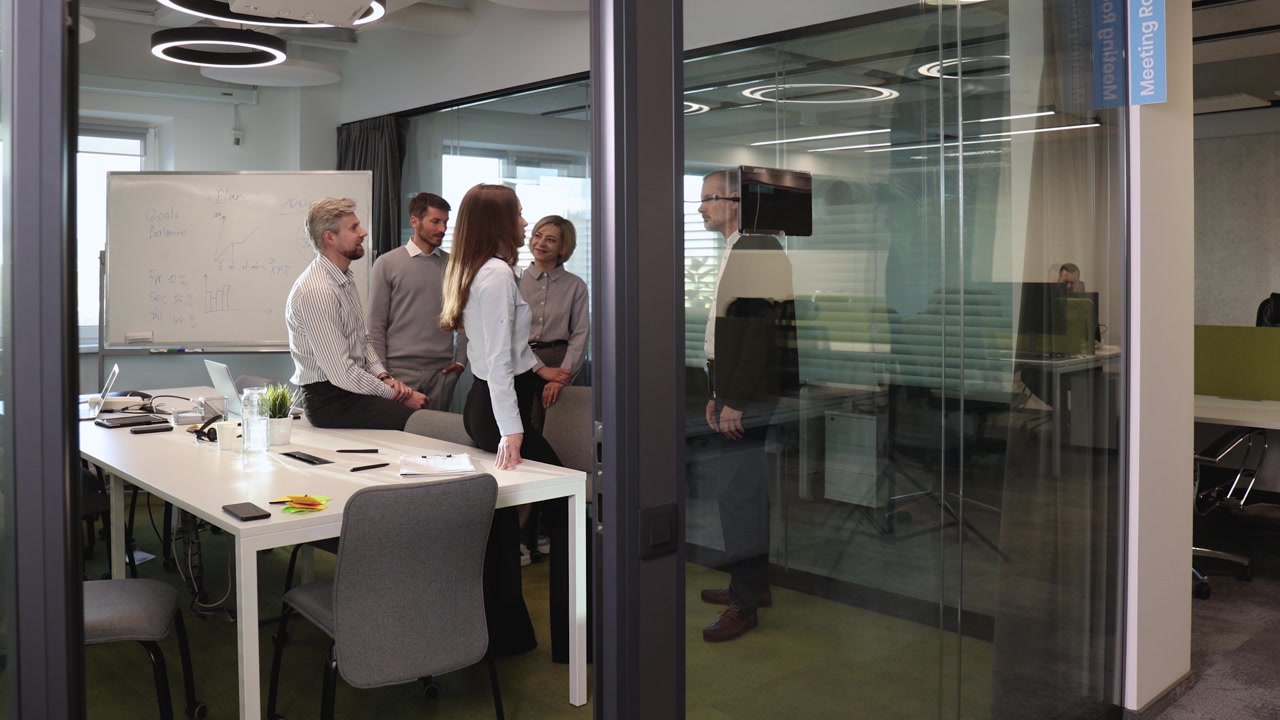 Diverse Business Team Collaborating in Modern Glass-Walled Office
