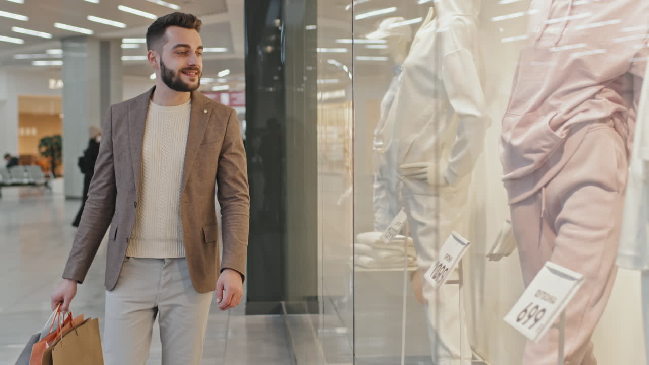 Man Looking At Window Display Of Clothing Store