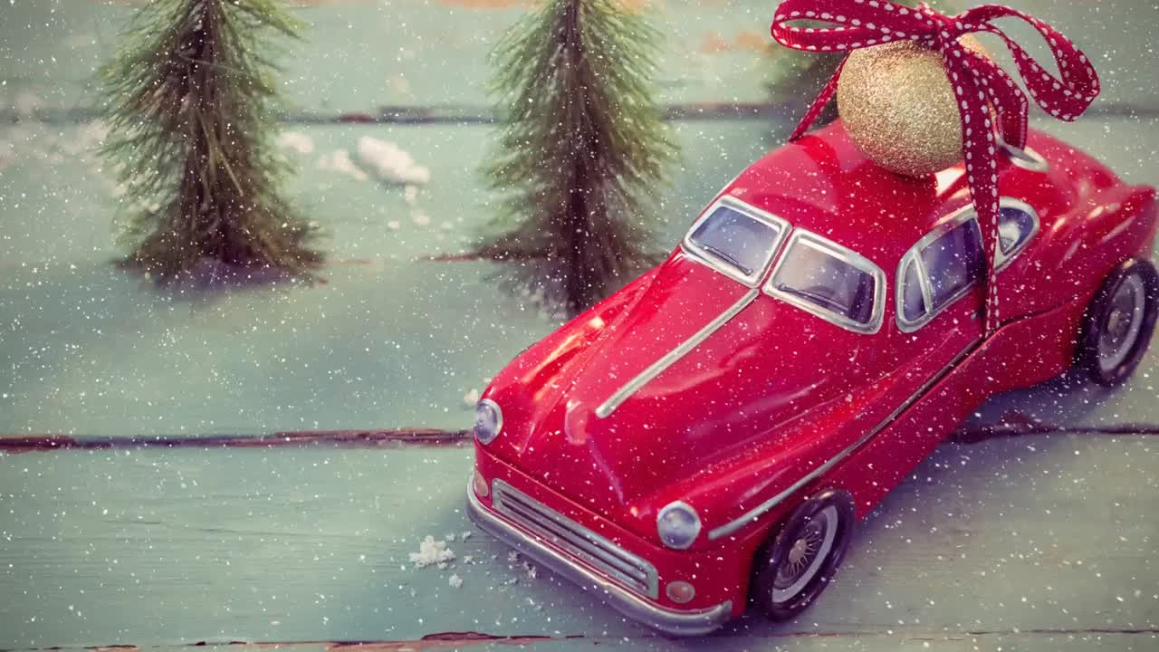 Modellino di auto rosso unito a neve che cade