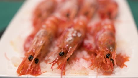 Cocina-Casera-Plato-De-Camarones-Rojos-Cocidos-Al-Horno,-Realzados-Con-Sal-Marina,-Roban-La-Atención-En-Un-Plato-Blanco