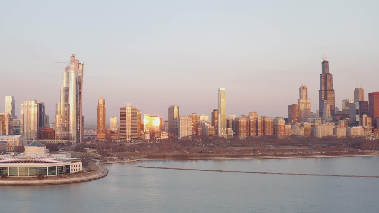 해가 지는 동안 왼쪽 아래에 창고 수족관이 있는 시카고 스카이라인의 드론 샷