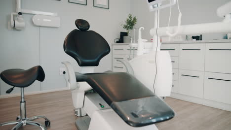 a dental office with a black leather dentist chair and white equipment