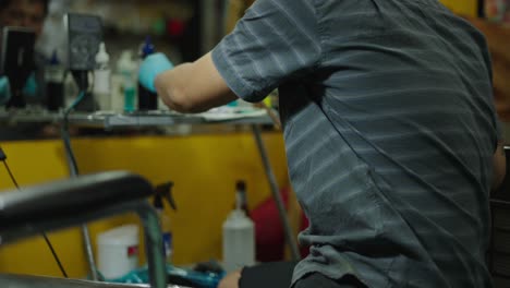 a person with tattooed arms and blue gloves in a tattoo studio