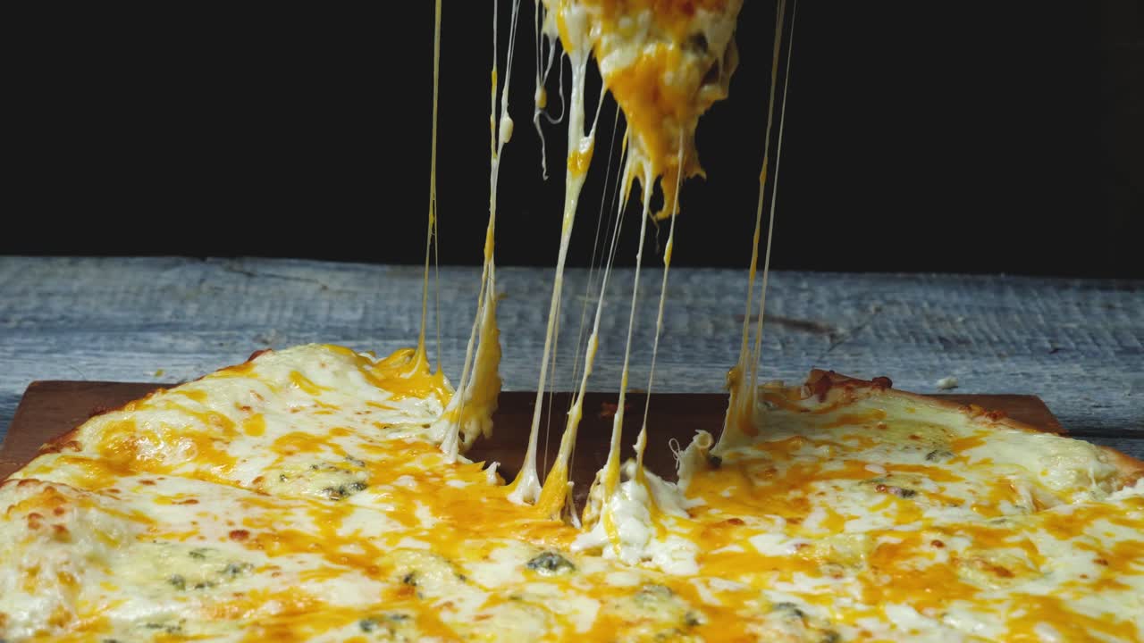 mano sosteniendo una rebanada de pizza con queso