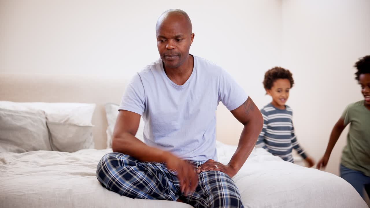 Stress, padre e bambini che corrono nella camera da letto di casa
