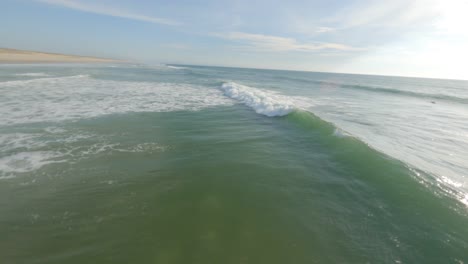 Drone-flying-around-isolated-surfer-surfing-wave,-Soustons-in-Landes-department,-France