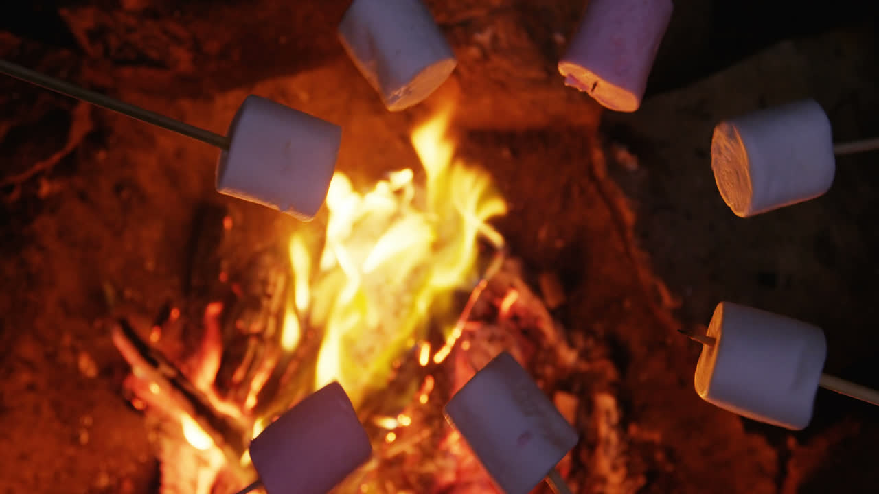 un primer plano de los excursionistas poniendo guimauves