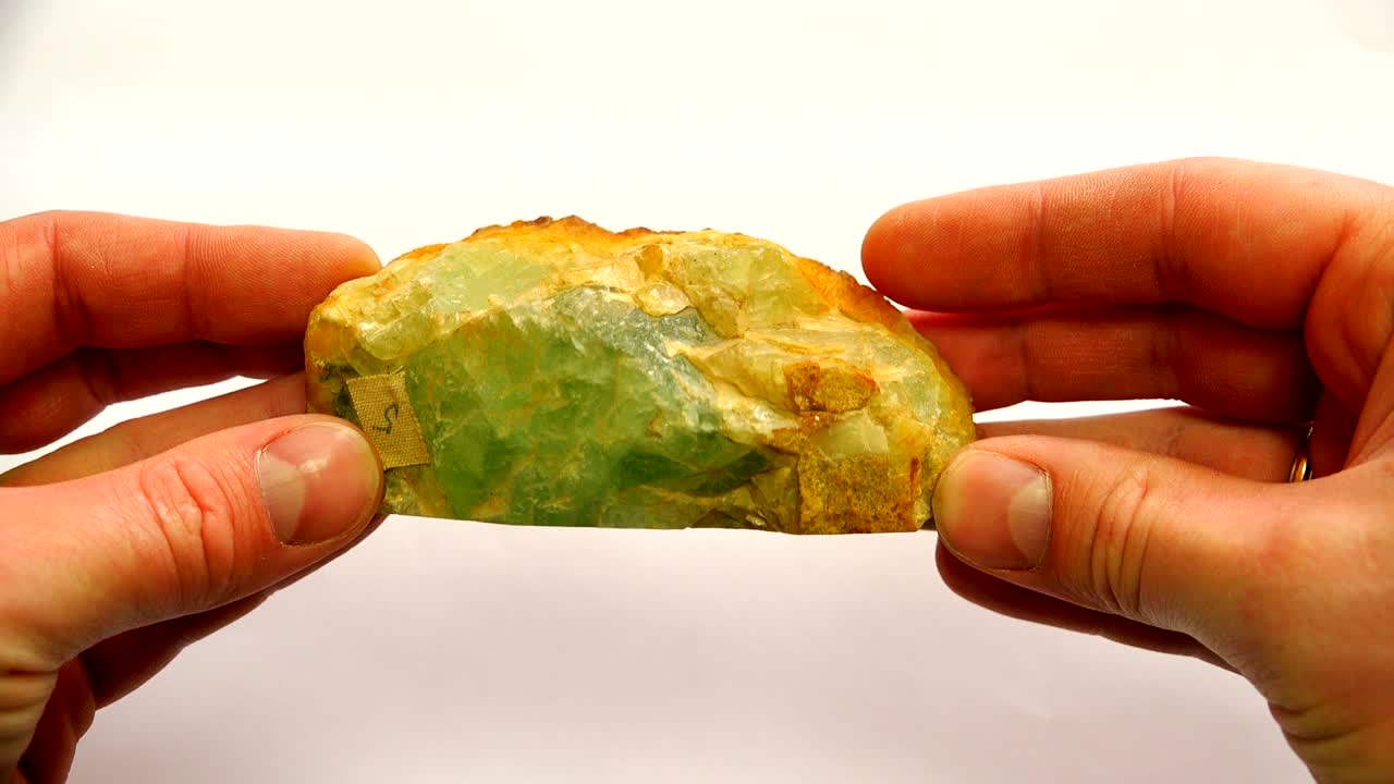 한쪽에 거친 오렌지색 표면을 가진 녹색 미네랄