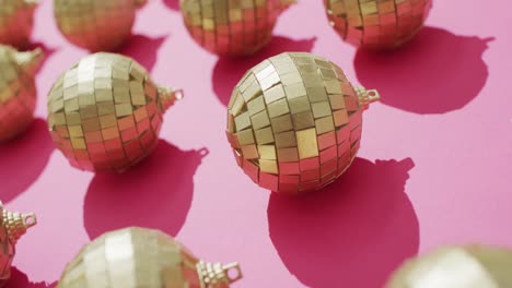 Video-of-rows-of-mirror-balls-and-their-shadows-on-pink-background