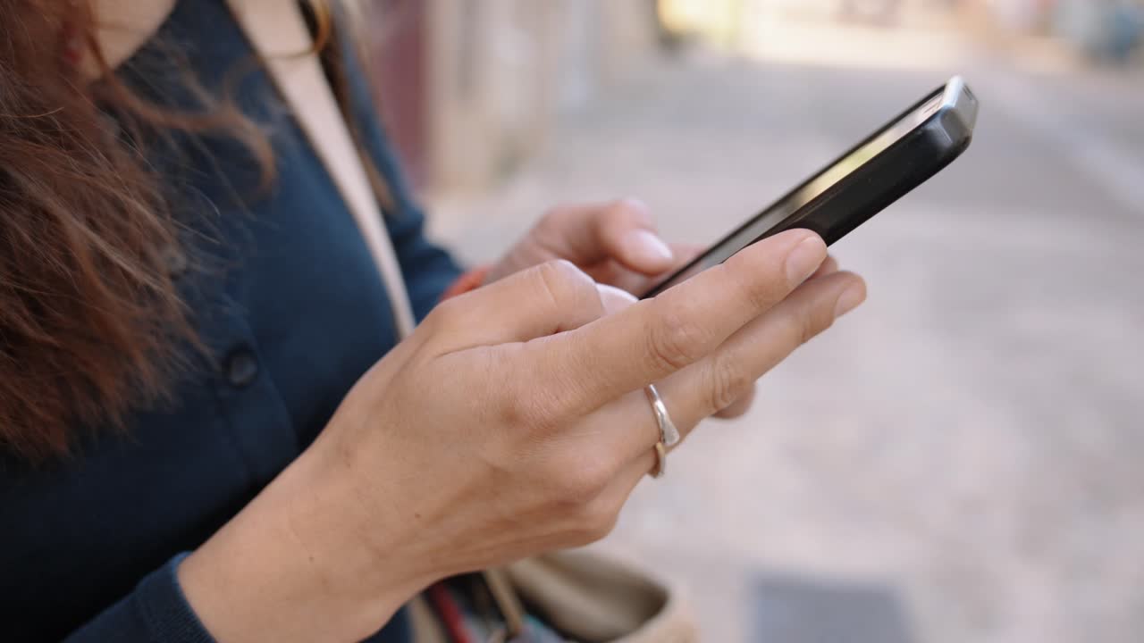 Digital routine, focus moment, sunny calm. Woman Using Smartphone While Walking Outdoors