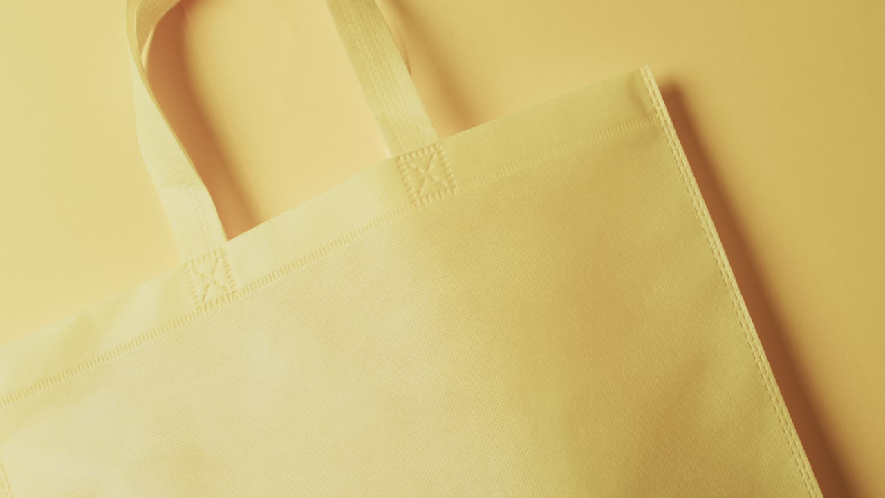 video de una bolsa de lona amarilla con espacio de copia en un fondo amarillo