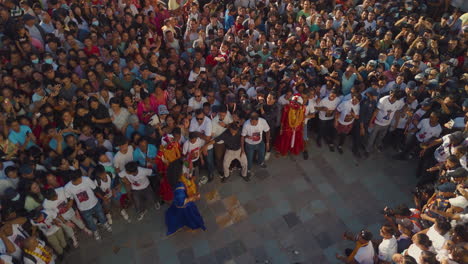drone shot captures huge crowd surrounding basantapur durbar square in kathmandu, nepal, for indra jatra celebration lakhe dancers attempt to scare people, adding excitement to the festive season
