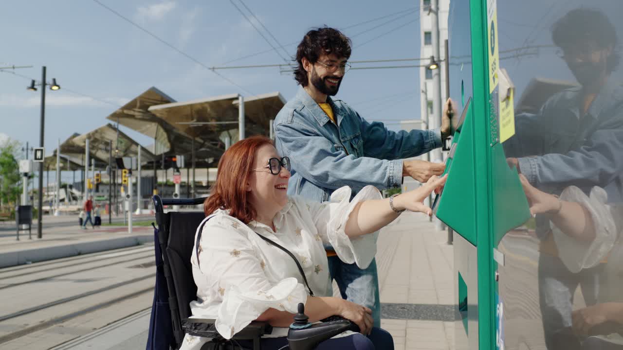Woman in wheelchair buying ticket with assistant
