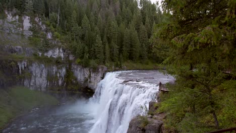 Drone-Aerial-trucking-left-to-right-of-the-Upper-Mesa-Falls,-a-thunderous-curtain-of-water-–-as-tall-as-a-10-story-building-Near-Island-Park,-and-Ashton,-Idaho