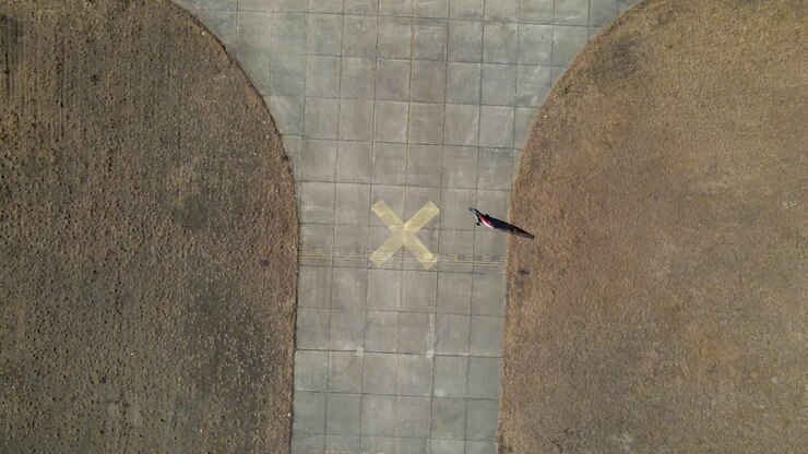 Aerial Birds Eye view of land sailing buggy circling an X on a disused airfield