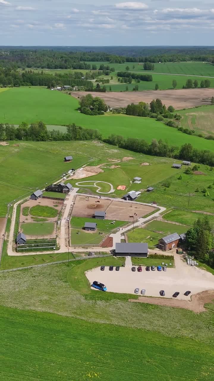 Scenic vertical aerial view of small countryside zoo with wildlife animal enclosures and rural landscape views in a sunny summer day