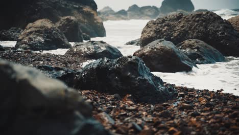 ocean tide hitting rocks on beach