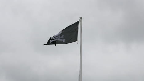 pirate scull and crossbones flag flying in the wind on a flag pole