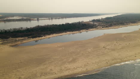 Aufsteigende-Luftaufnahme-Einer-Wunderschönen-Landschaft-Mit-Weichselmündung,-Umgeben-Von-Einem-Naturschutzgebiet-Mit-See-Und-Sandbank