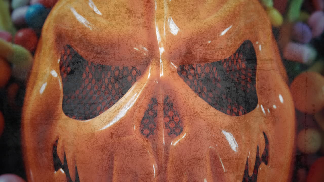 cráneo naranja y caramelos contra un fondo parpadeante