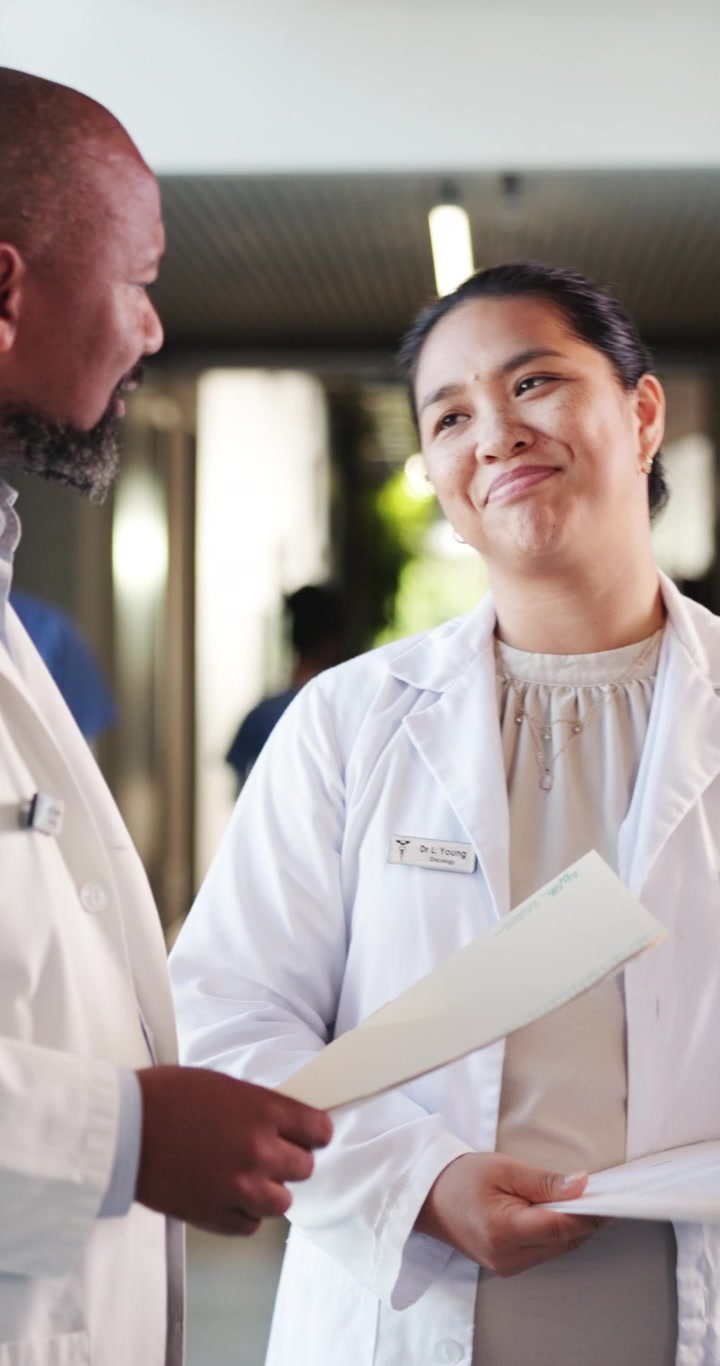 Due medici che discutono le cartelle dei pazienti nel corridoio dell'ospedale