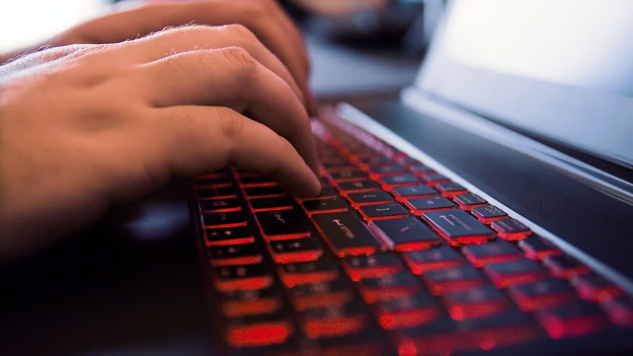 hombre escribiendo en una computadora portátil - visto desde un lado