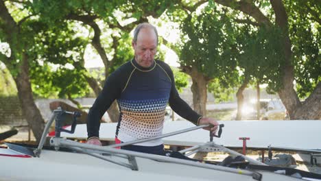 senior caucasian man preparing rowing boat for the water