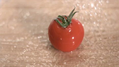 el agua llueve sobre el tomate en súper cámara lenta.